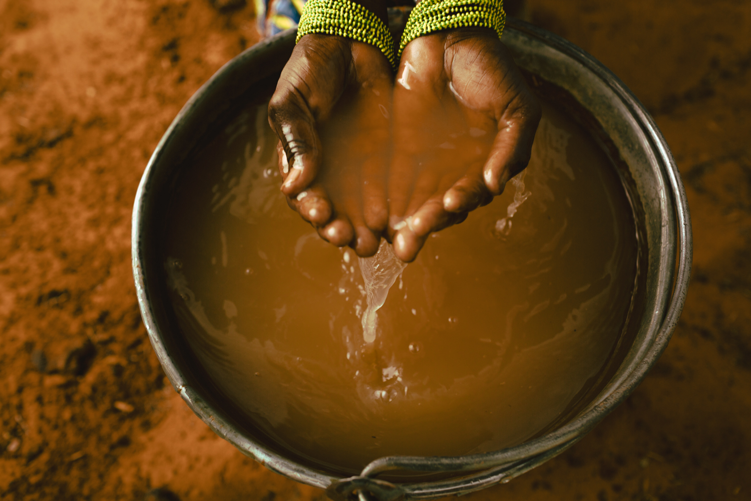 Hands in muddy water